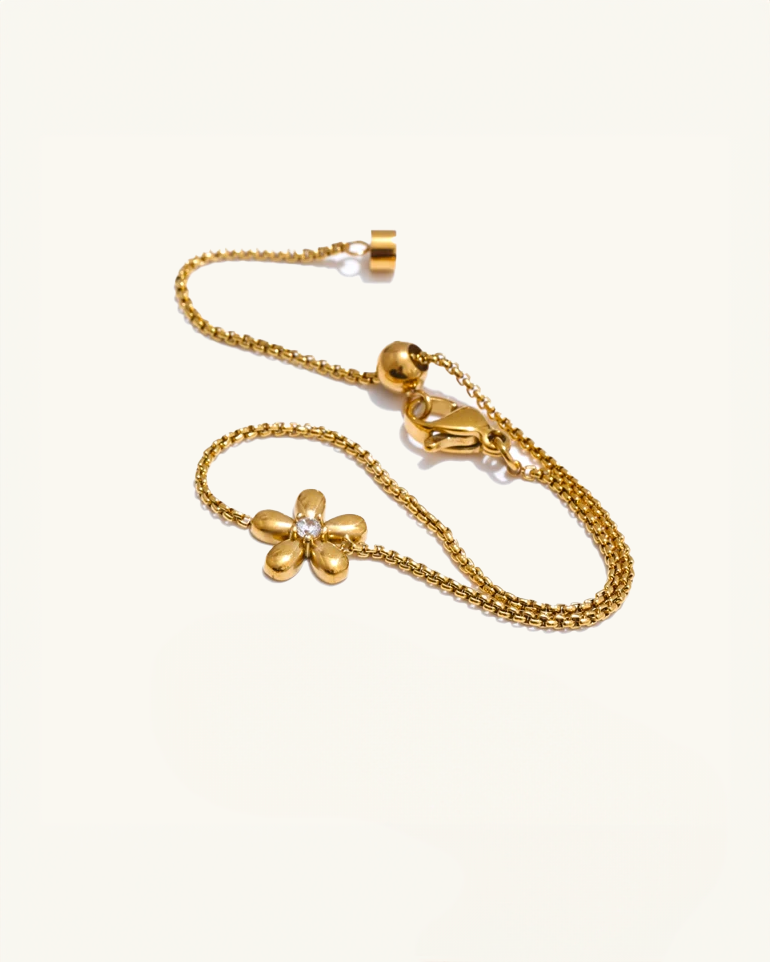Close-up of flower charm and slider clasp – gold waterproof bracelet with floral design