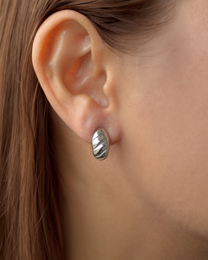 Lia spiral silver earrings worn on ear – sculptural, waterproof, and non-tarnish