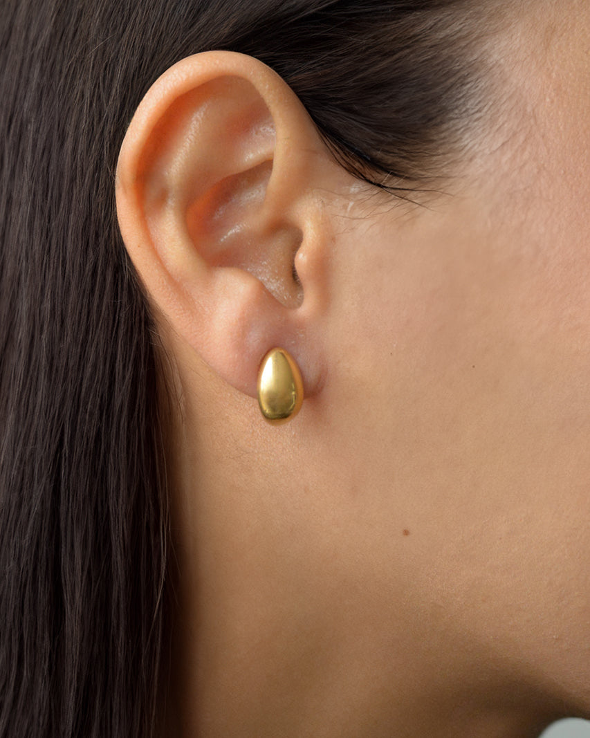 Lira gold teardrop stud earrings worn on ear – waterproof and everyday-safe
