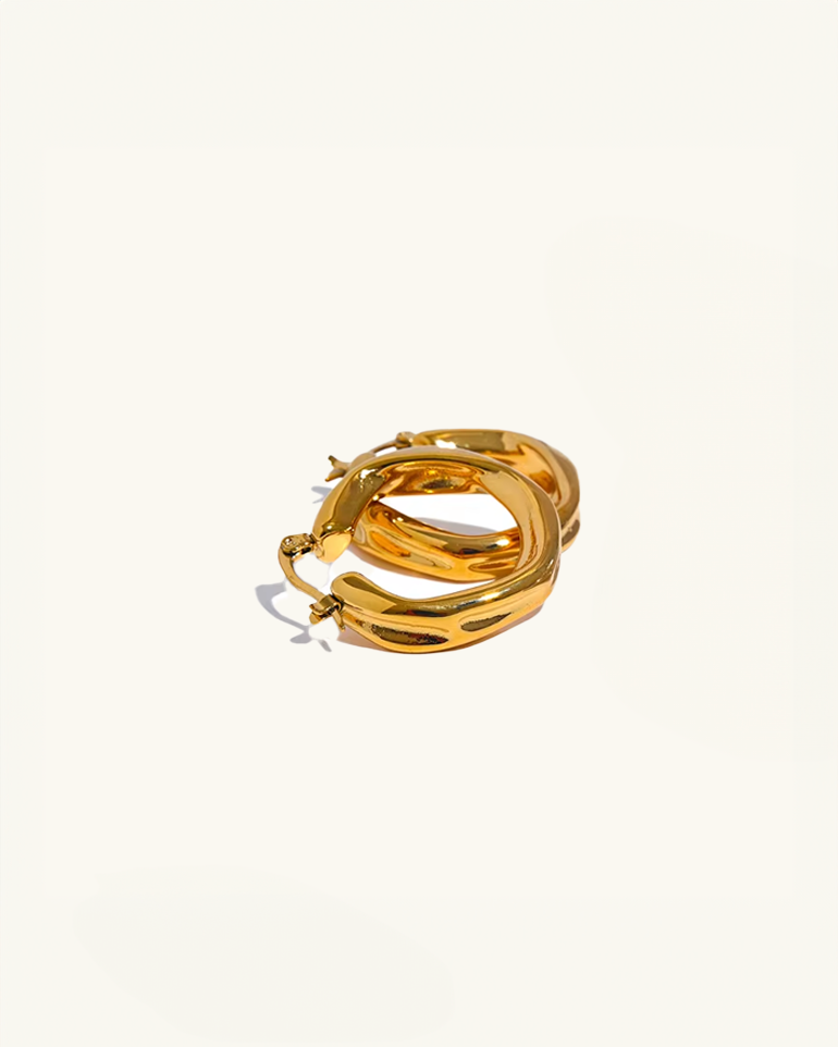 Pair of Luz gold twist hoops laid flat – hypoallergenic and tarnish resistant